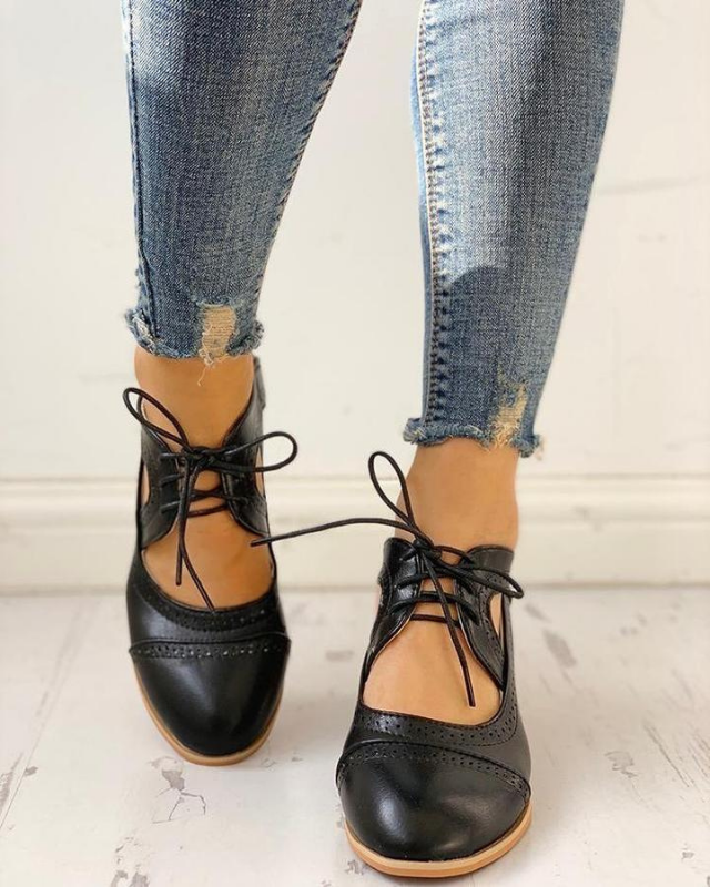 Black Women’s PU Leather Brogue Heeled Boots on the model